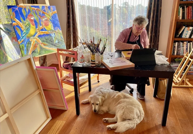Heather at work at table w dog underneath Heather at work at table with dog underneath